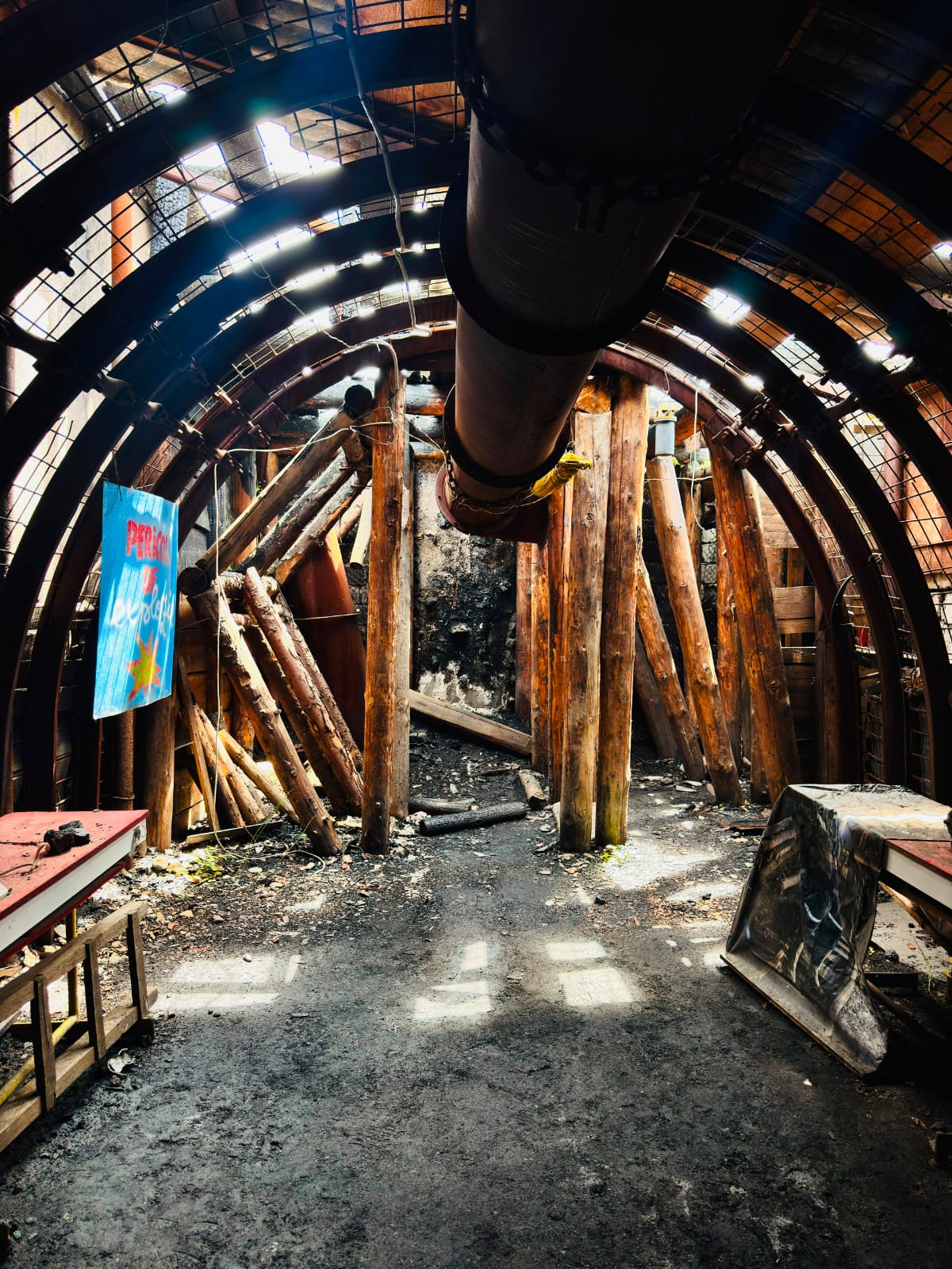 Inside the mine tunnel with timber supports and metal arches